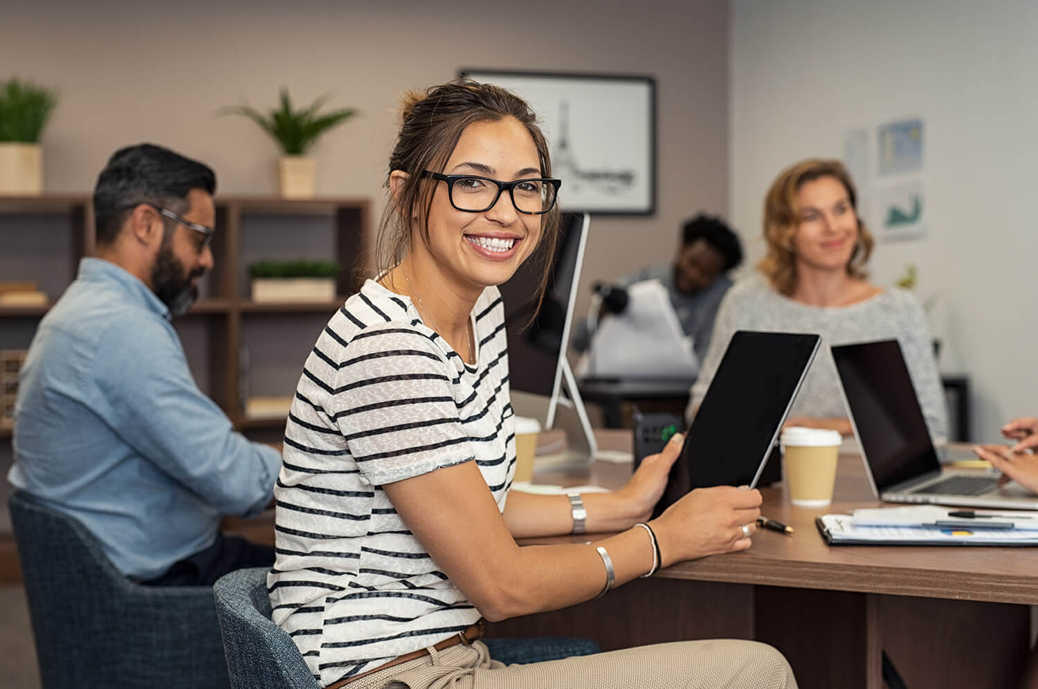 Smiling hispanic woman holding a computer tablet